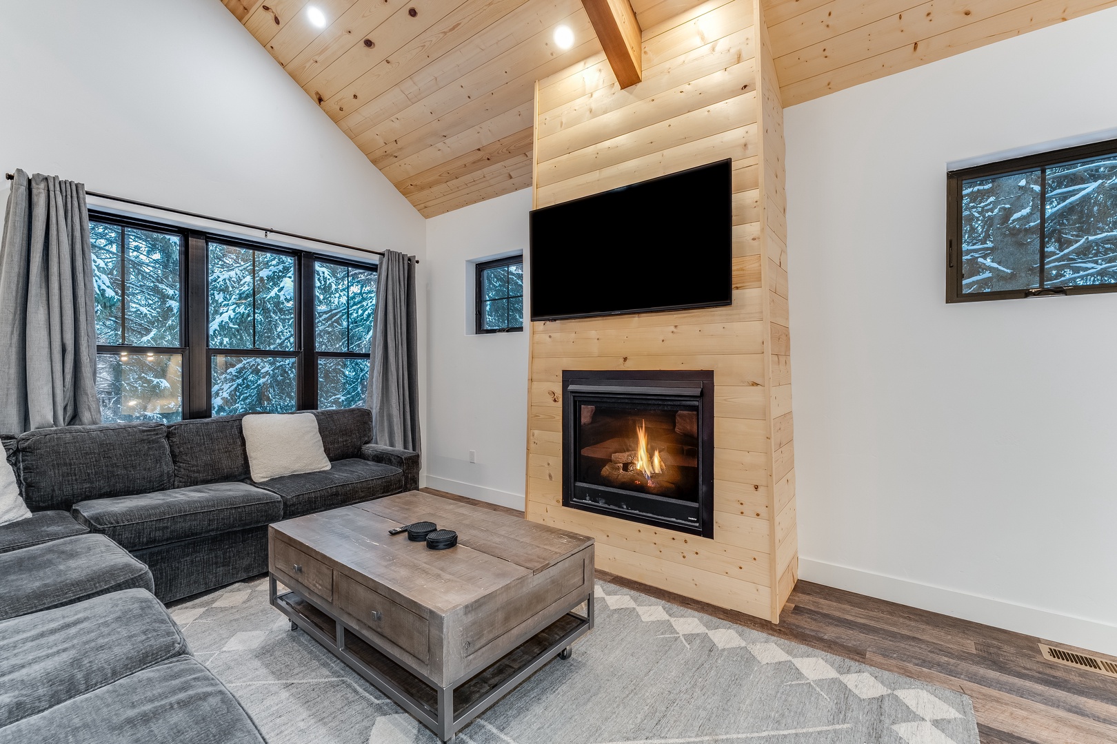 Cozy up by your crackling fireplace while watching TV from the plush sectional sofa, surrounded by warm wood and mountain views.