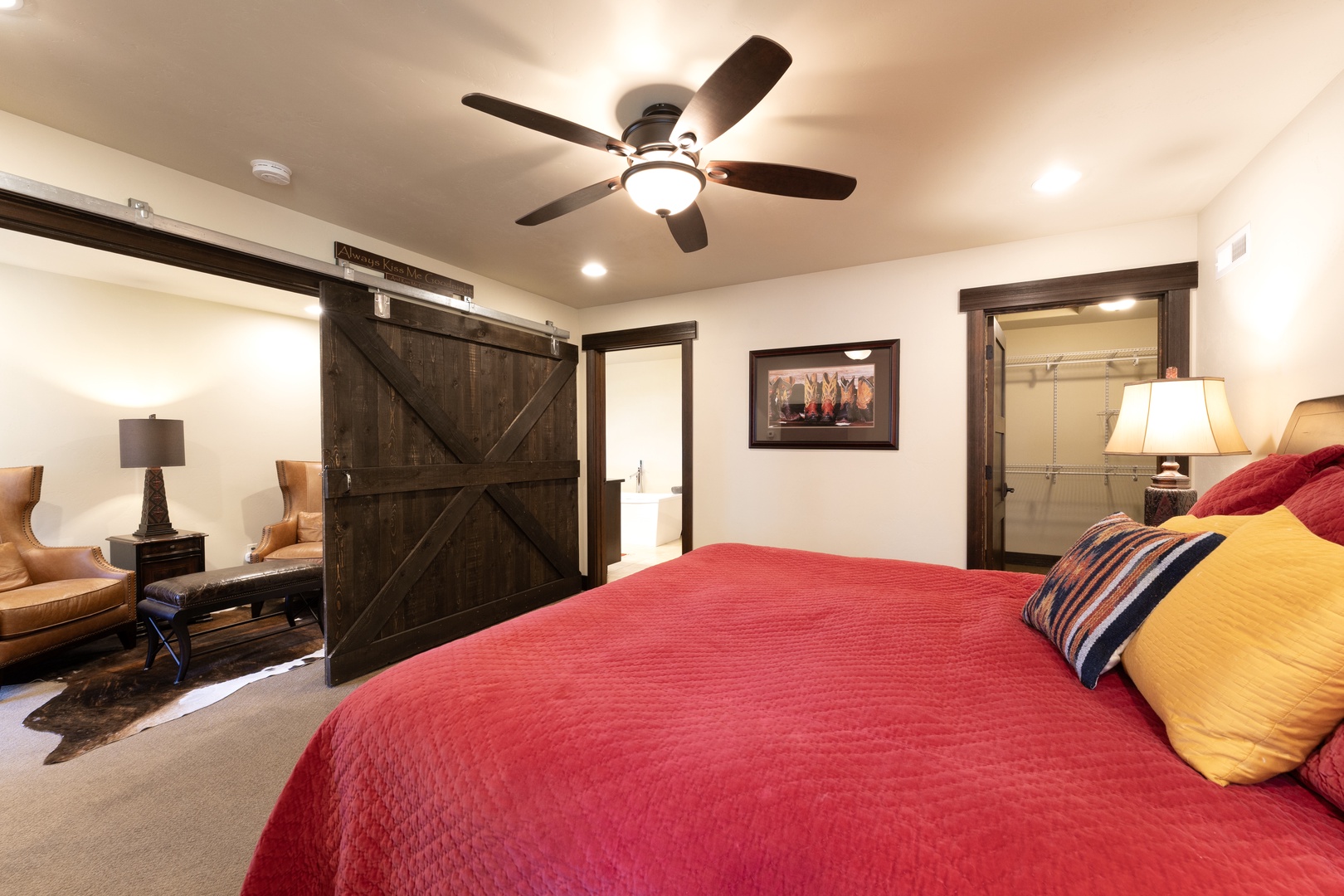 Unwind in your cozy bedroom featuring rustic barn-door charm, plush seating, and an en-suite bathroom—your personal retreat after a day of adventure.