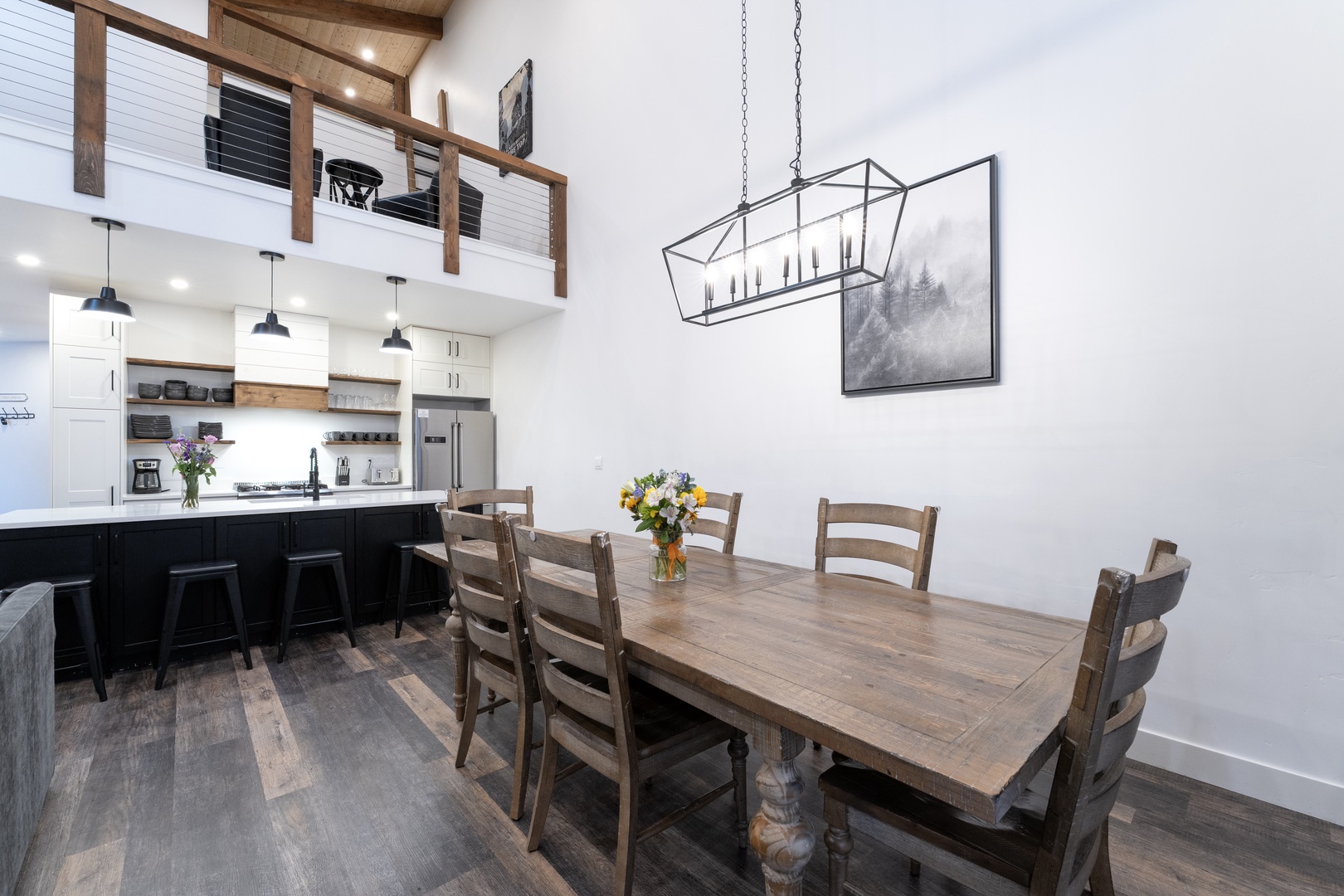 Gather around this rustic dining table for memorable meals, with your gourmet kitchen just steps away and soaring ceilings creating an airy, welcoming atmosphere.