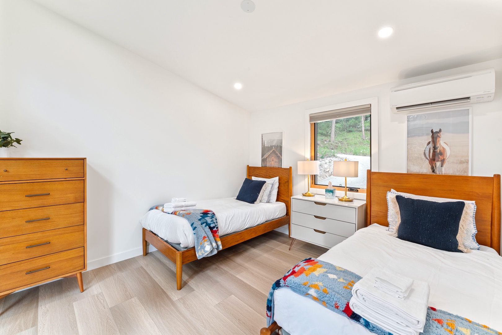 Rest peacefully in your cozy twin bedroom, featuring warm wood furnishings and crisp white linens.