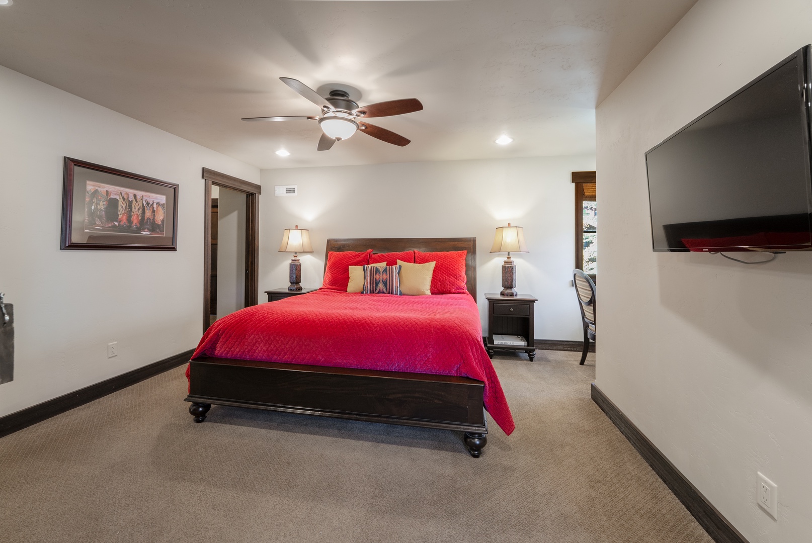 Sink into your plush bed after a day exploring the area, with soft lighting and a ceiling fan ensuring your perfect night's rest awaits.