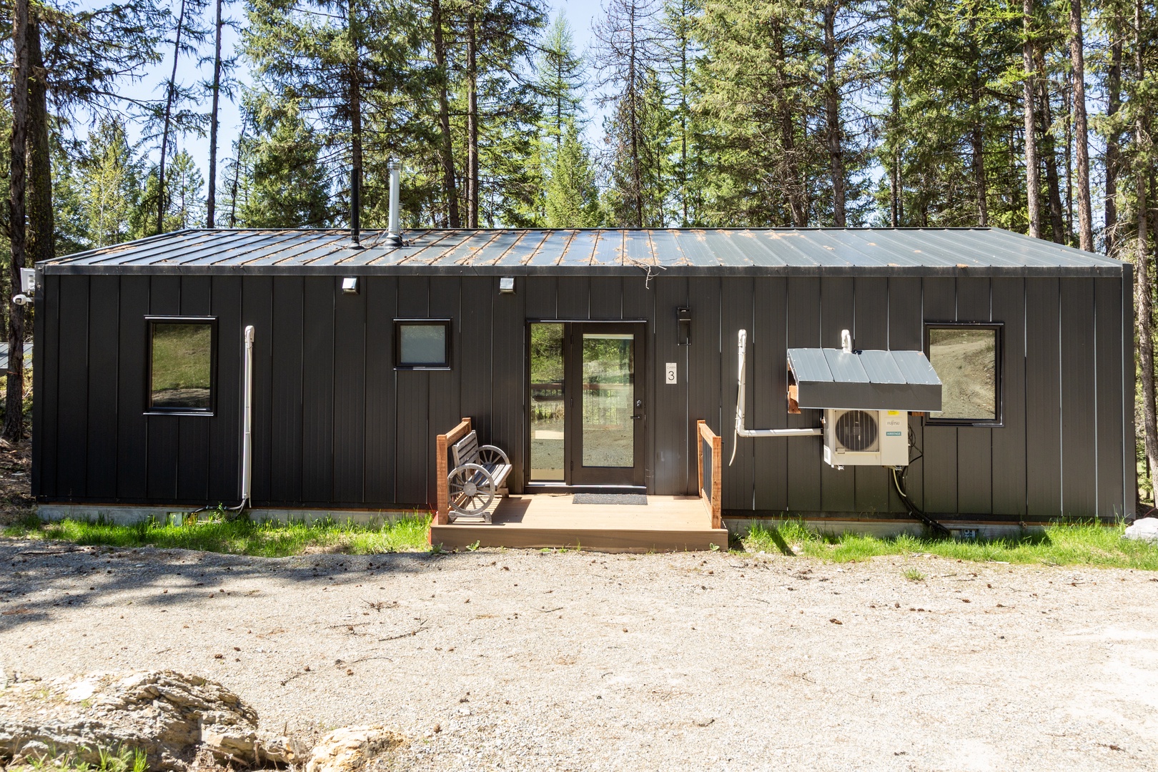 Modern cabin nestled in a tranquil forest setting, offering peaceful seclusion surrounded by towering pines and natural beauty.