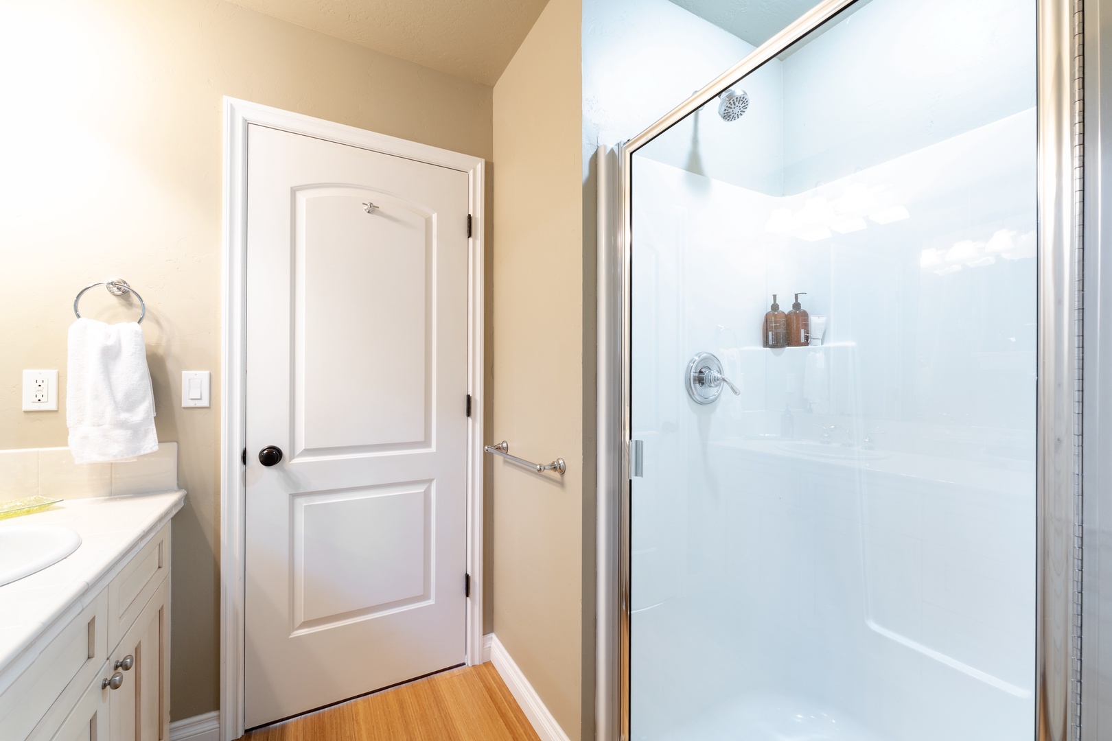 Step into your bright, sparkling clean bathroom with a glass-enclosed walk-in shower, fresh towels at the ready, and warm, welcoming tones that make you feel right at home.