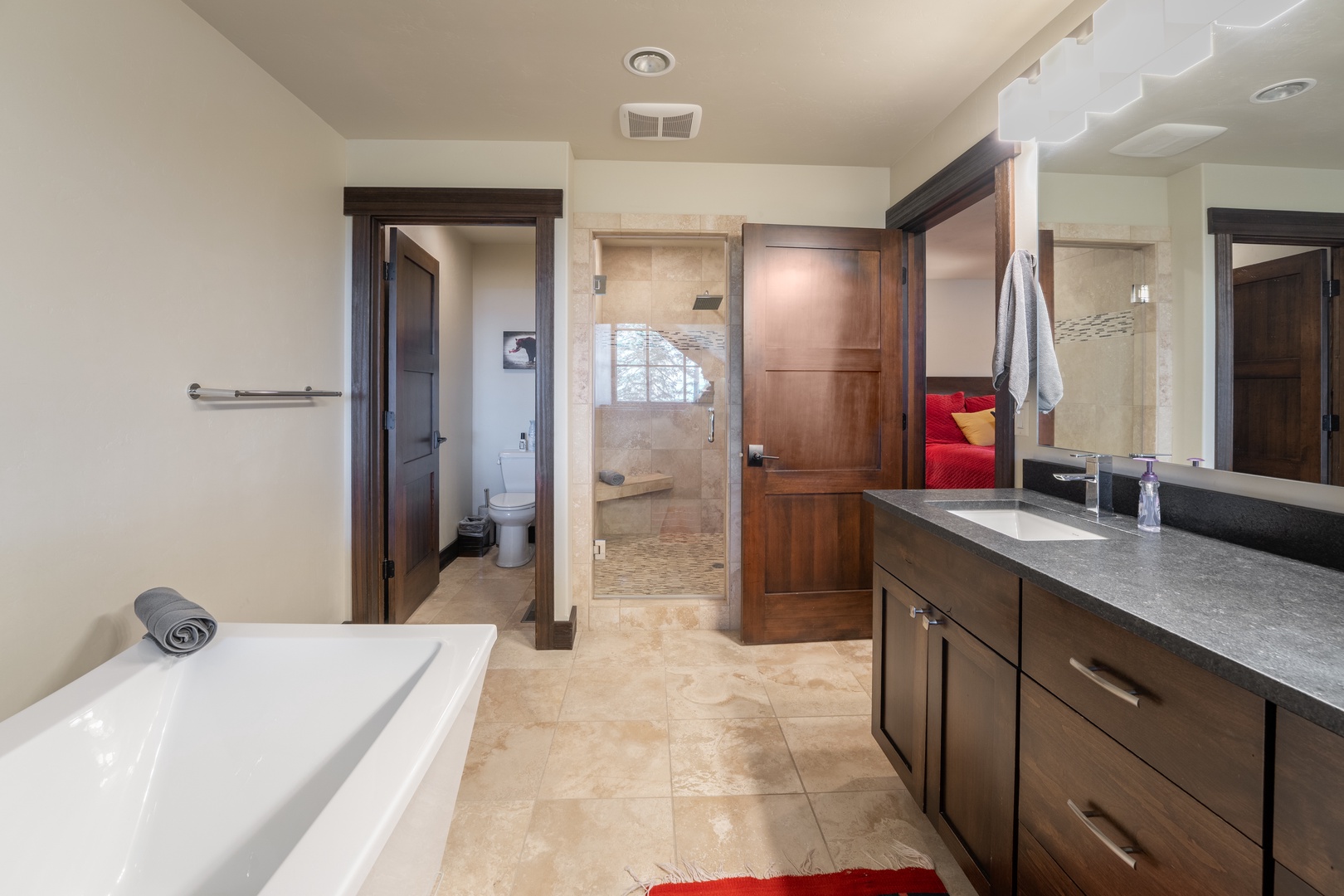Your private spa-like bathroom awaits with a deep soaking tub, walk-in shower with elegant tile work, and generous vanity space for a truly relaxing retreat.
