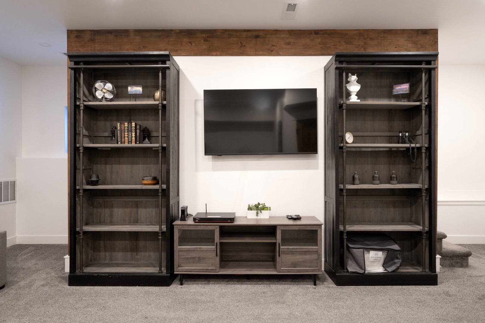 Settle into your entertainment center with built-in shelving displaying books and decor, creating the perfect spot for movie nights.