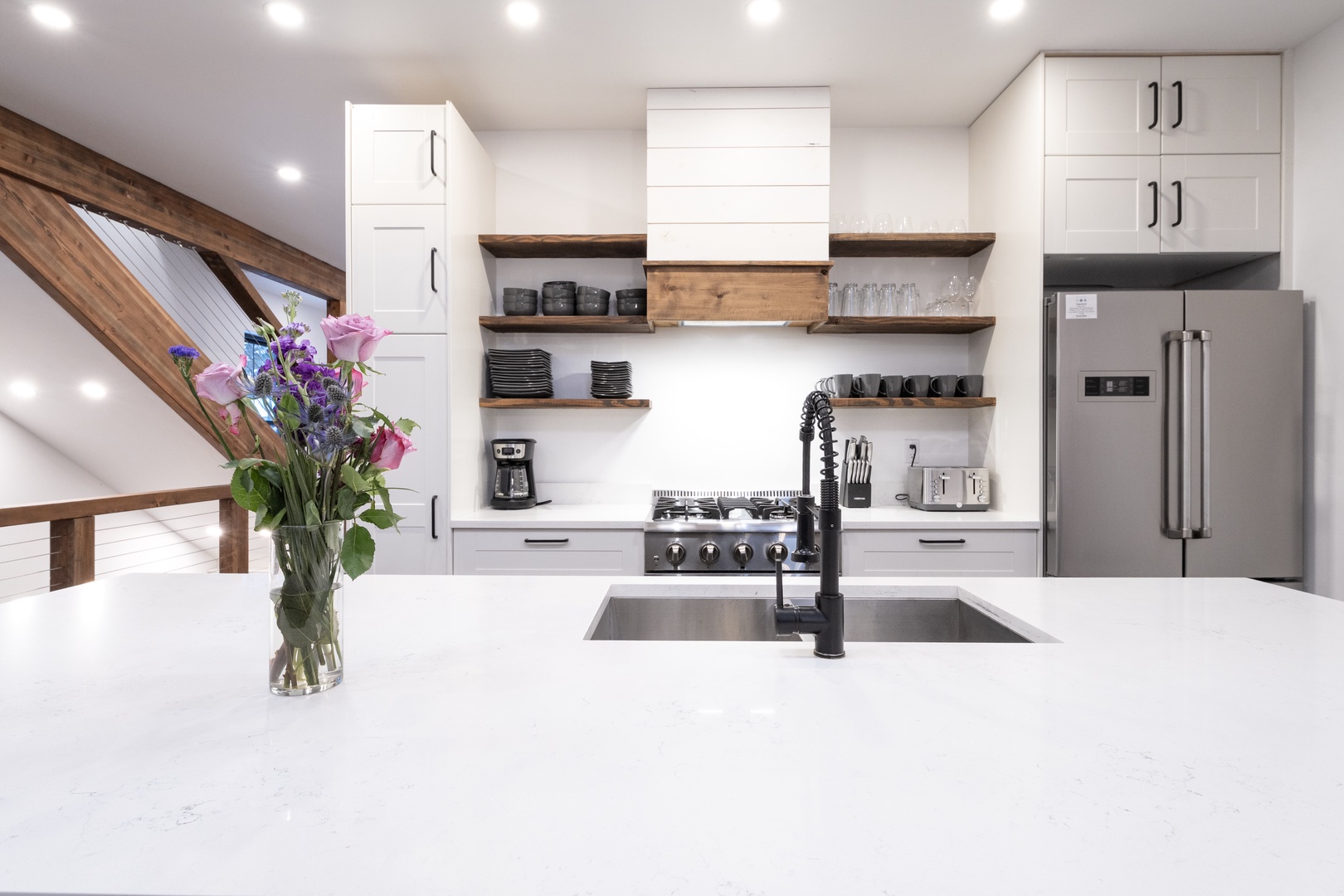 Your modern kitchen awaits with sleek white countertops, stainless steel appliances, and warm wood shelving for all your culinary adventures.