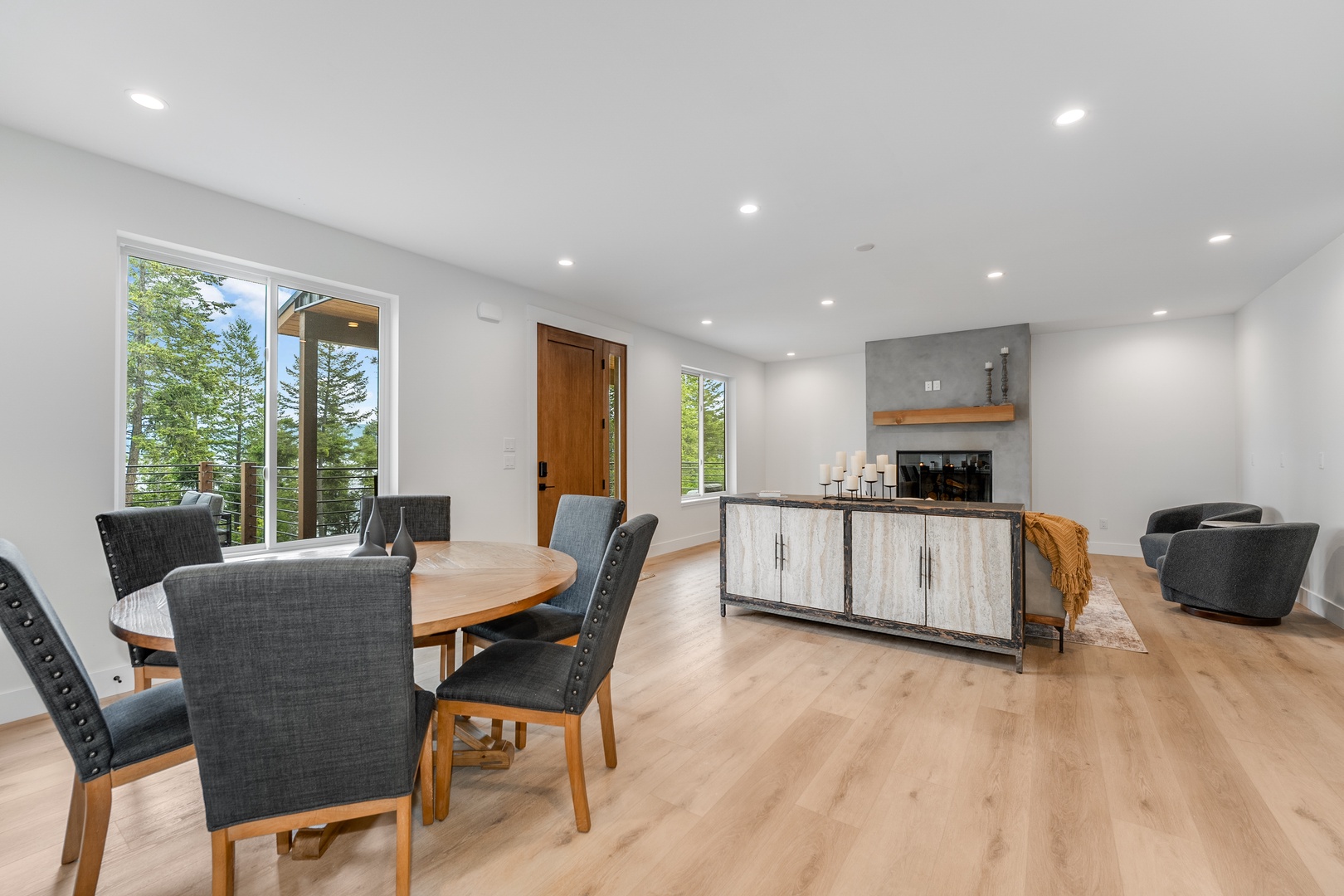 Step into your open-concept living space where natural light flows through floor-to-ceiling windows. Gather around the dining table with loved ones, or unwind in the seating area with mountain views framing every moment of your stay.