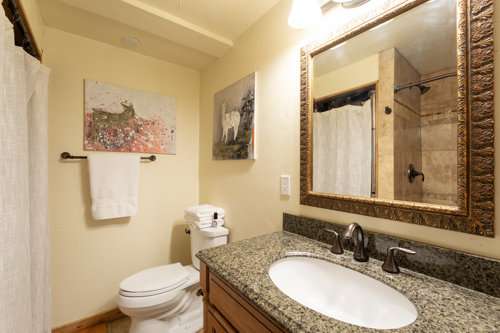 Your private bathroom features granite countertops, an ornate mirror, and thoughtful artwork to create a refined retreat.