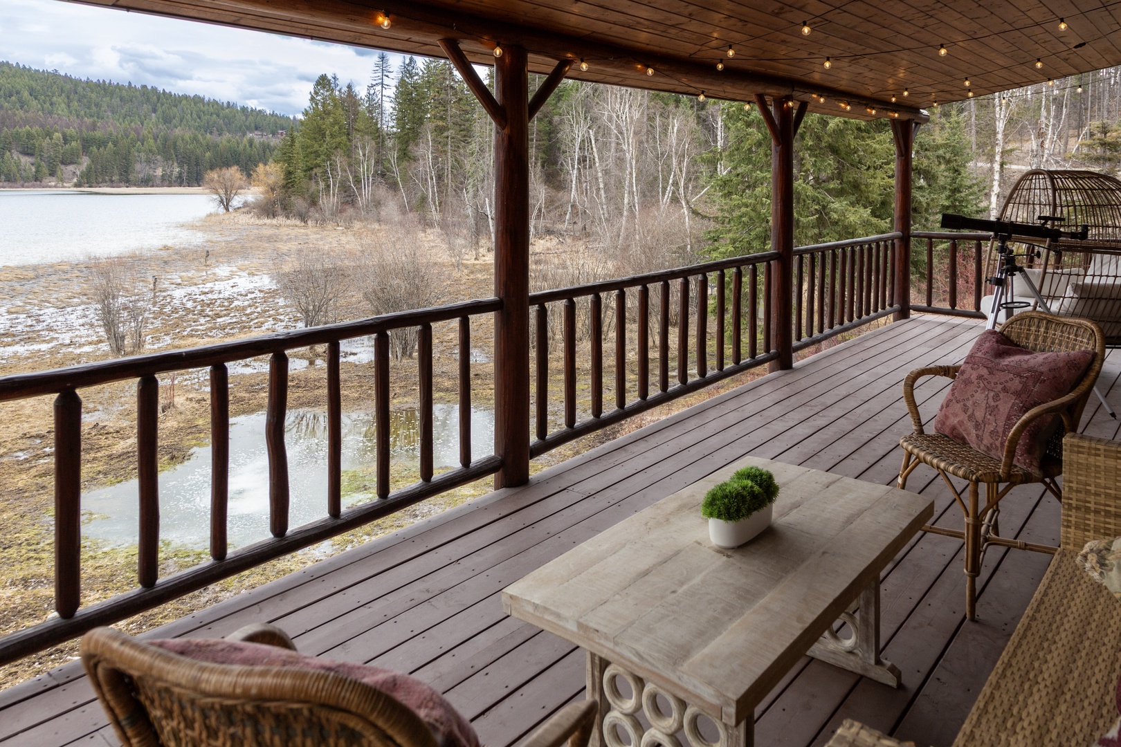 Unwind on your private covered deck with wicker seating while taking in peaceful lake and mountain views through the forest.