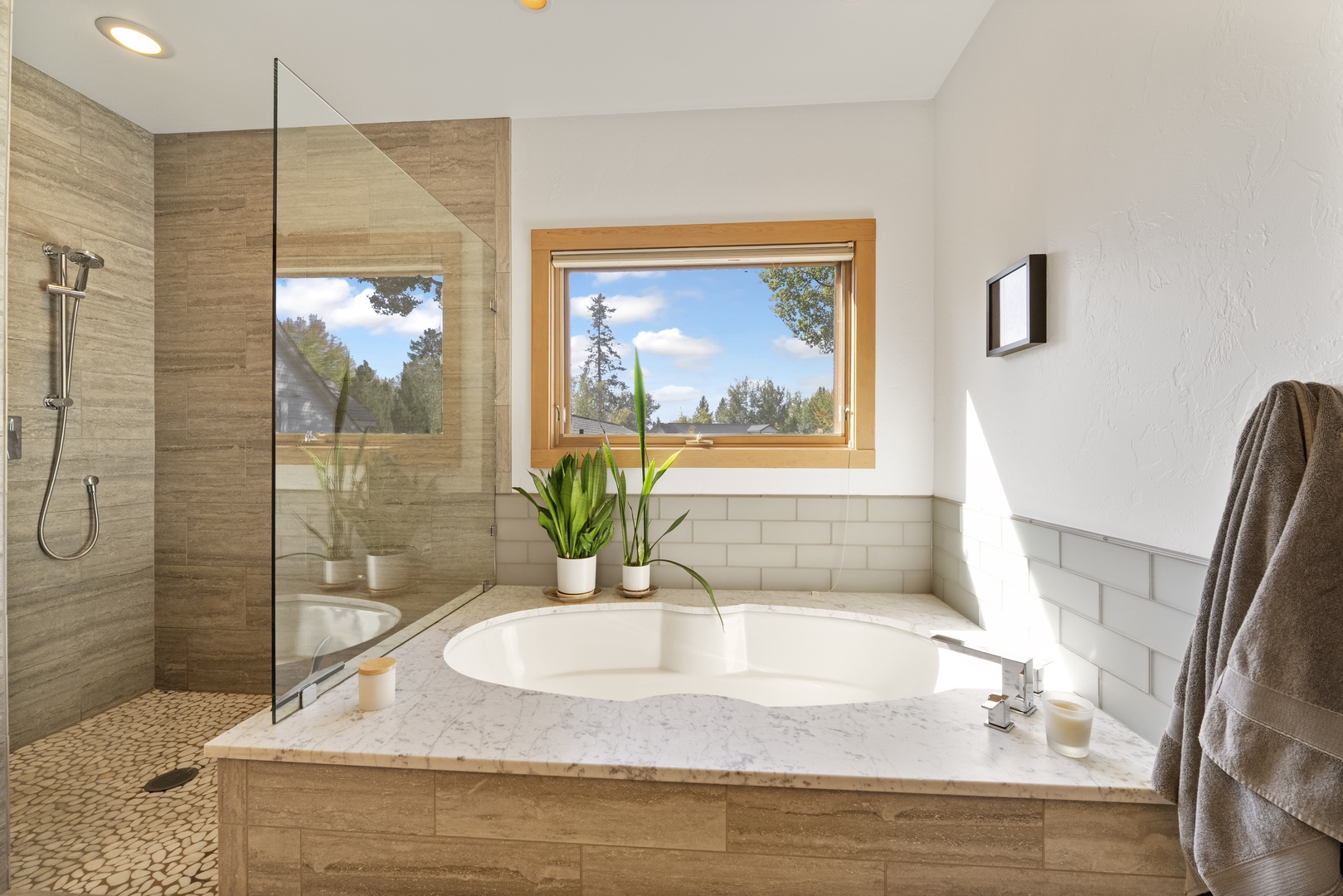 Sunlight pours through the window as you settle into your private soaking tub, with a spacious walk-in shower just steps away. Natural textures and fresh greenery create a serene, spa-like retreat.