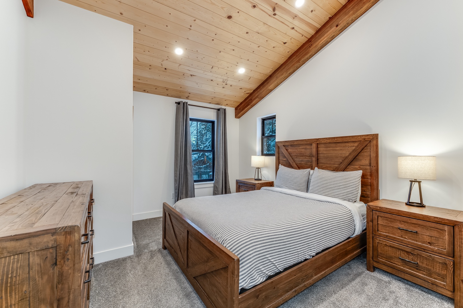 Drift off beneath stunning wood beams in your cozy retreat, where rustic charm meets modern comfort for the perfect mountain getaway.