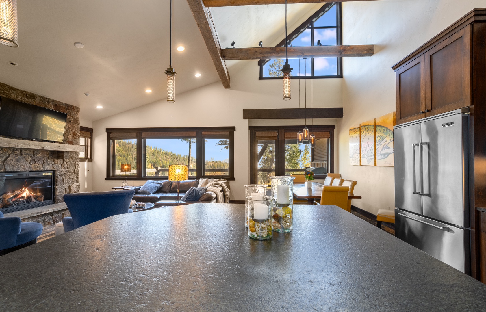 You'll love the open layout with exposed beam ceilings, a cozy fireplace, and stunning mountain views through large windows flooding the space with natural light.