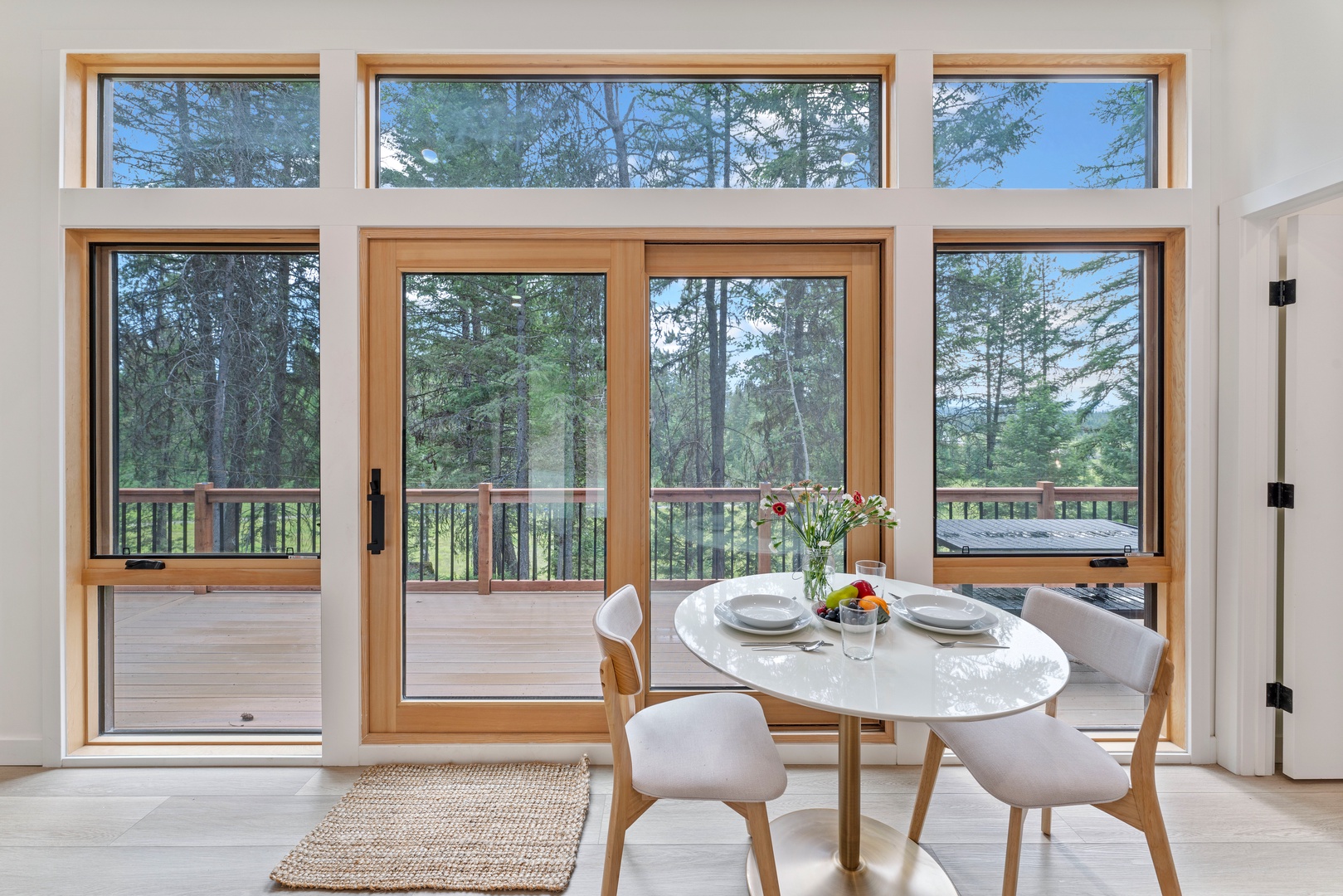 Savor meals in your bright dining space with stunning forest views through floor-to-ceiling windows that frame nature's beauty perfectly.