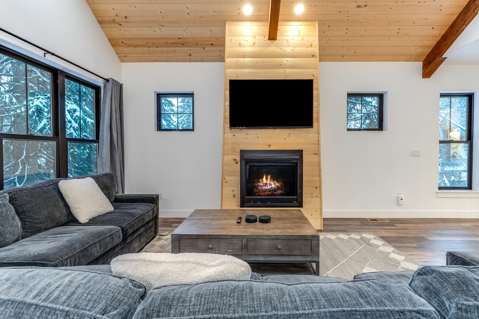 Cozy up on plush sectional seating while the fireplace crackles warmly beneath your favorite shows on the mounted TV.