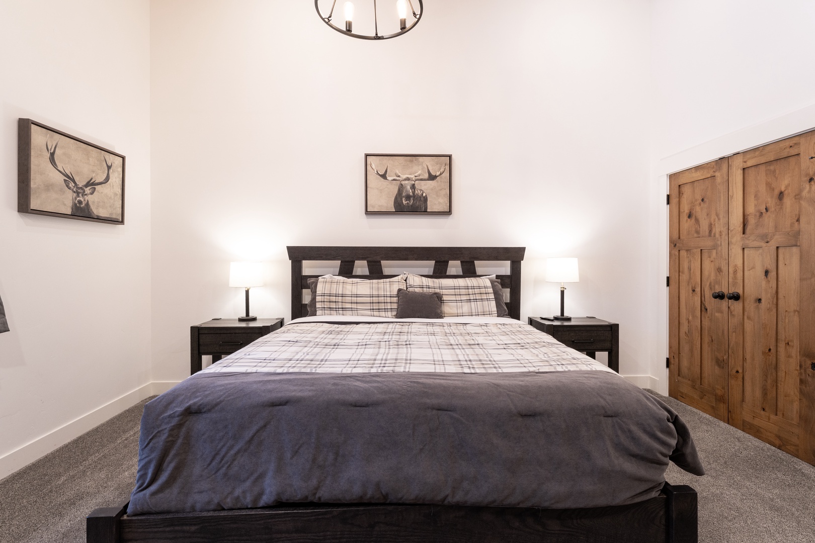 Unwind in your cozy bedroom featuring rustic charm with stag artwork, plaid bedding, and warm wood touches for peaceful nights.