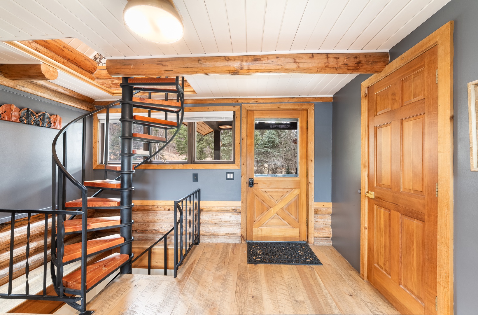 Step into your mountain retreat through rustic charm meets modern design, where exposed beams and warm wood create cozy elegance.