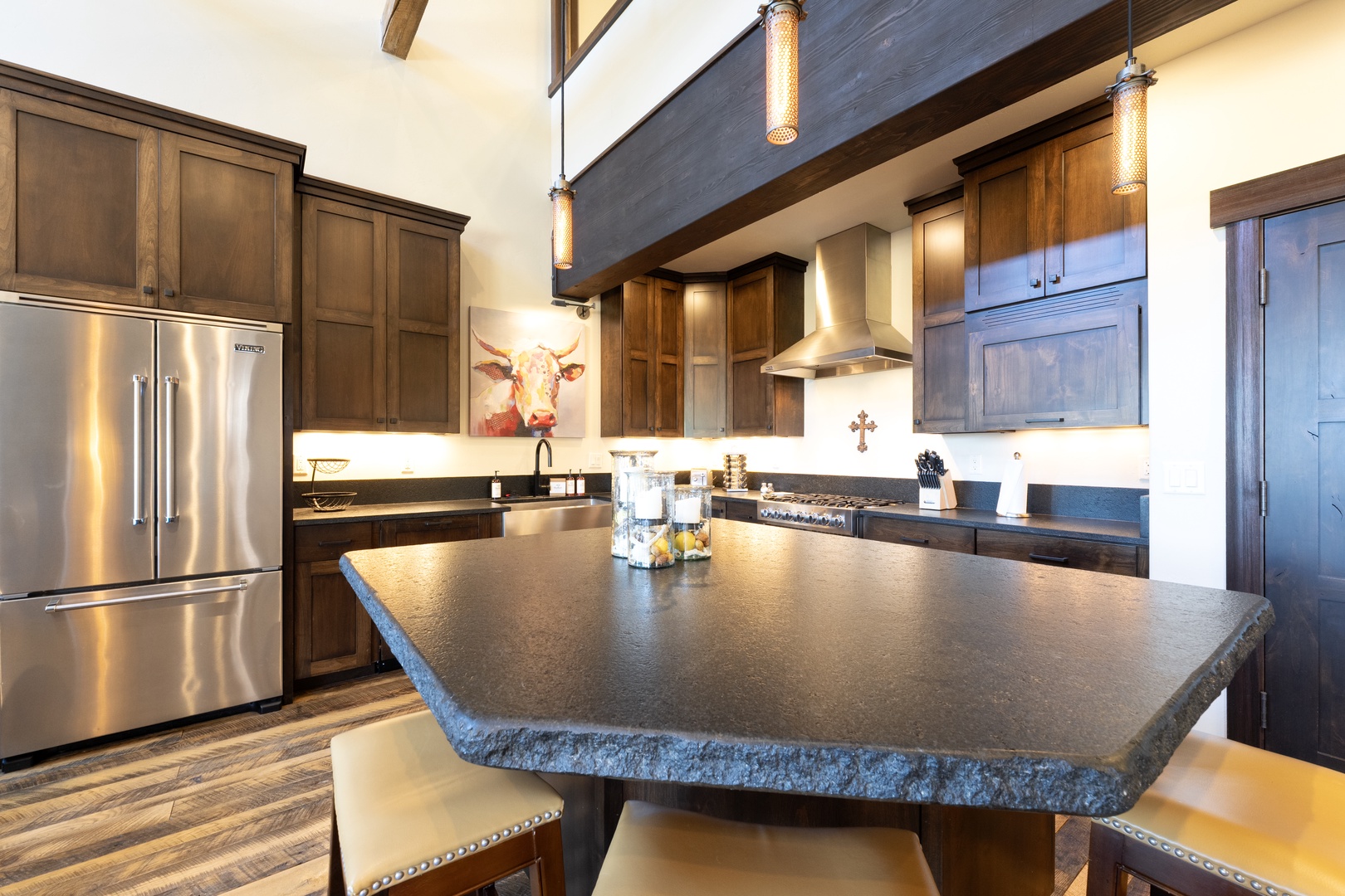Your gourmet kitchen awaits with rich wood cabinetry, a dramatic vaulted ceiling, and professional-grade appliances. The expansive island invites you to gather, cook, and create memories in this stunning space.