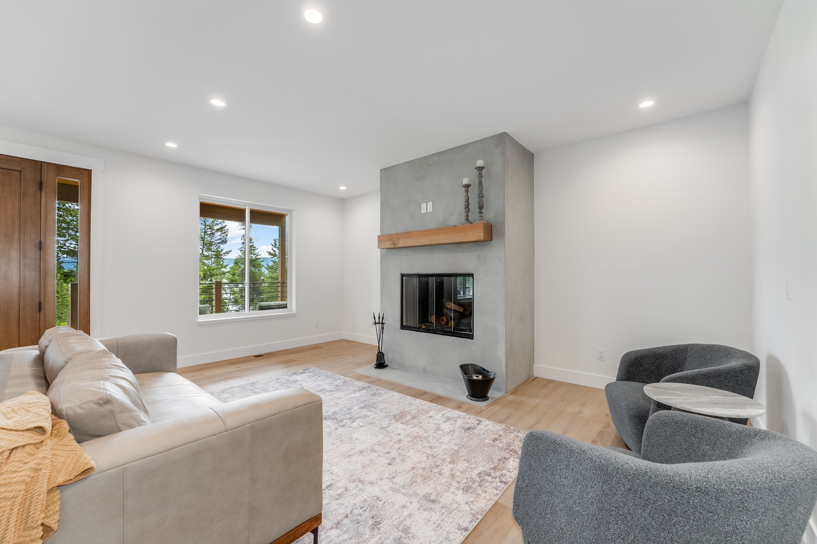 Unwind in your airy living room, where a modern fireplace and wood mantle create the perfect spot to relax after exploring. Plush seating and natural light invite cozy evenings with loved ones.