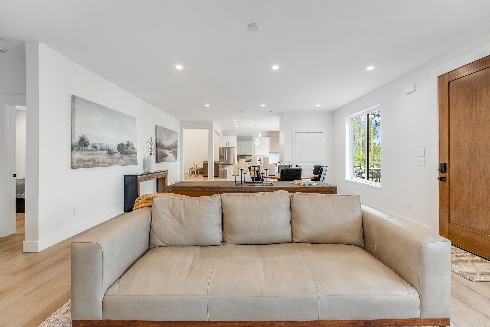 Settle into this open, sunlit living space where natural light pours through large windows, framing tree views. The leather sofa invites you to unwind after your adventures.