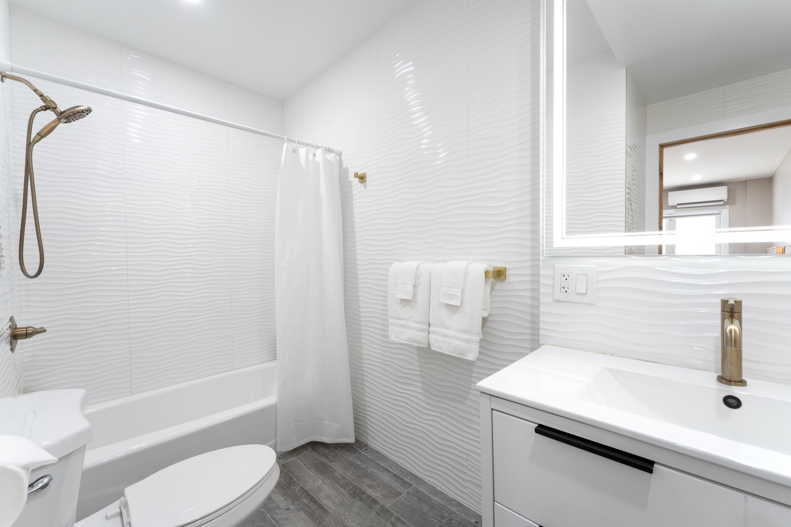 Your private bathroom features modern fixtures with a sleek tub-shower combo, plush towels, and warm brass accents—a crisp, calming retreat after each adventure.