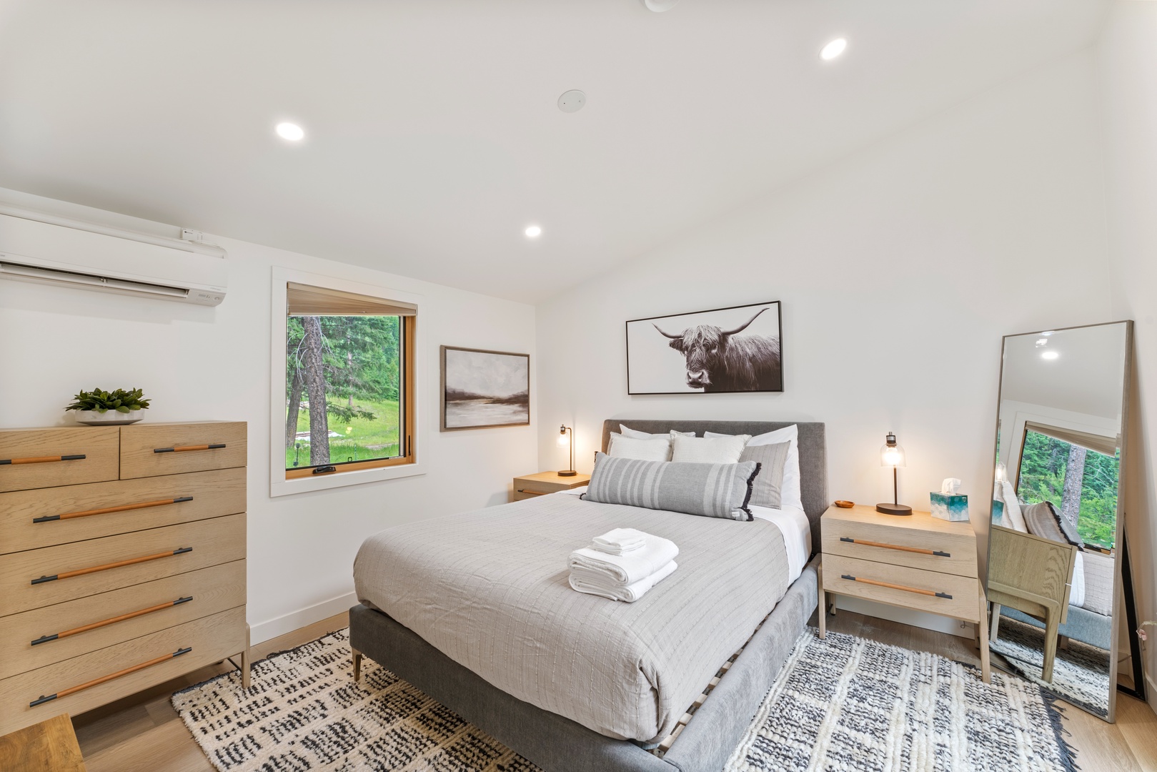 Unwind in your serene bedroom with fresh linens, warm wood furnishings, and natural light streaming through garden views—designed for your restful retreat.