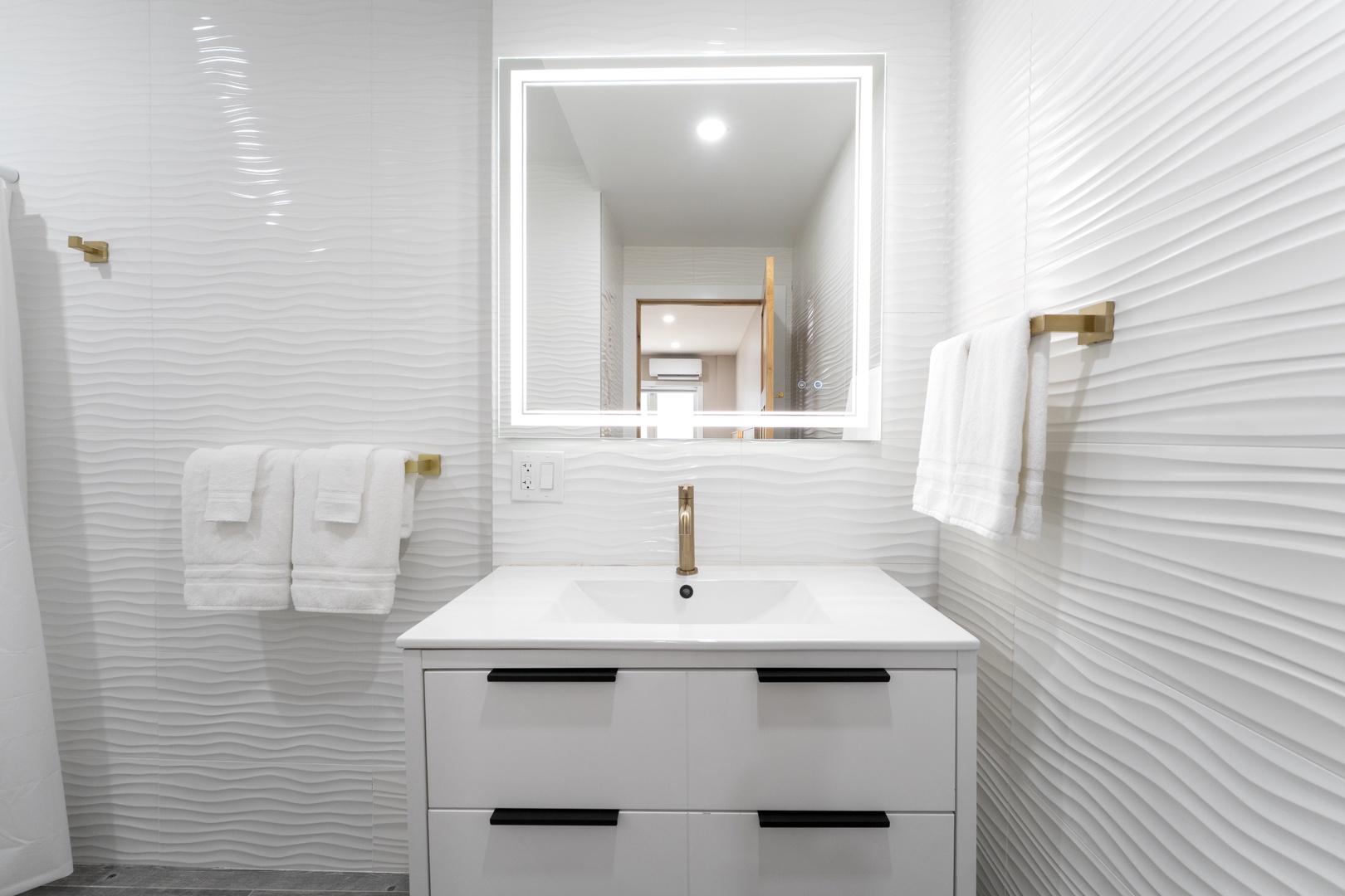 Step into your sleek, modern bathroom with crisp white textured walls, soft towels, and a bright vanity that makes getting ready feel effortless and refreshing.