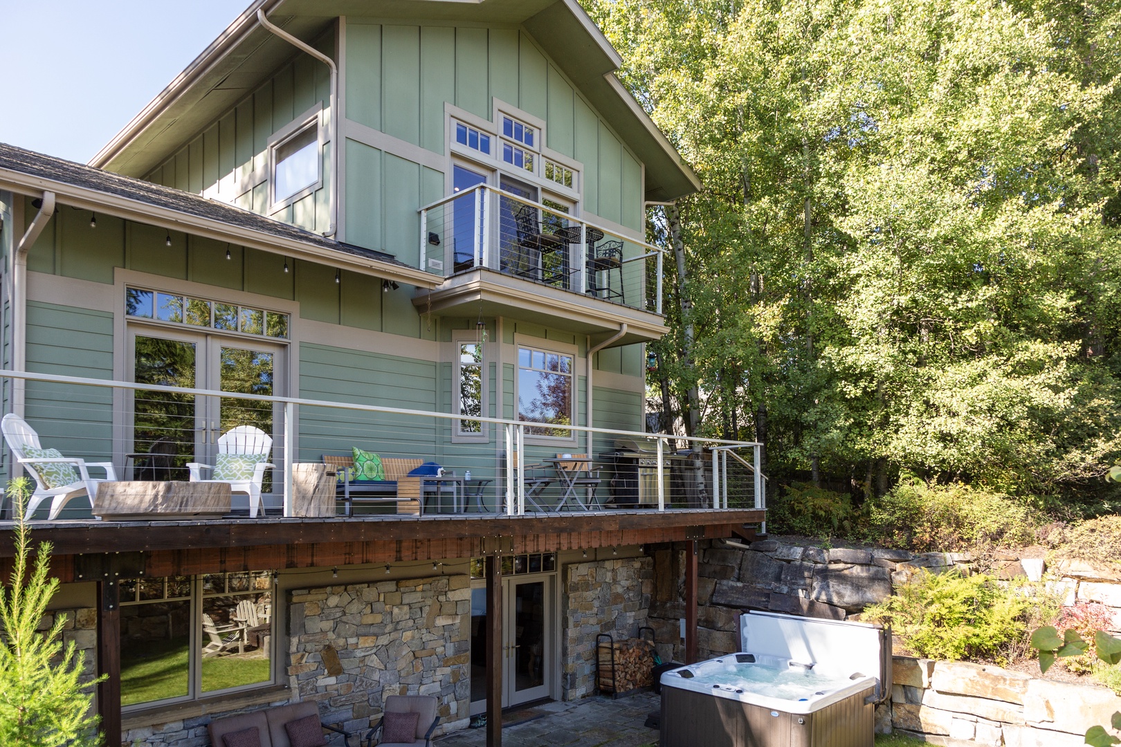 This peaceful retreat sits nestled among leafy trees, featuring spacious decks where you can relax in the open air or soak in your private hot tub with nature all around.