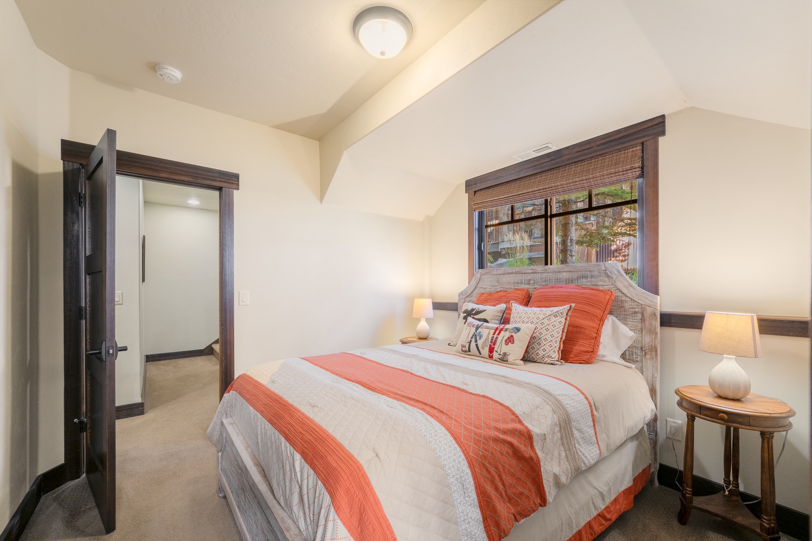Sink into plush comfort as soft lighting and warm wood tones wrap you in relaxation, with leafy views just beyond your restful retreat.