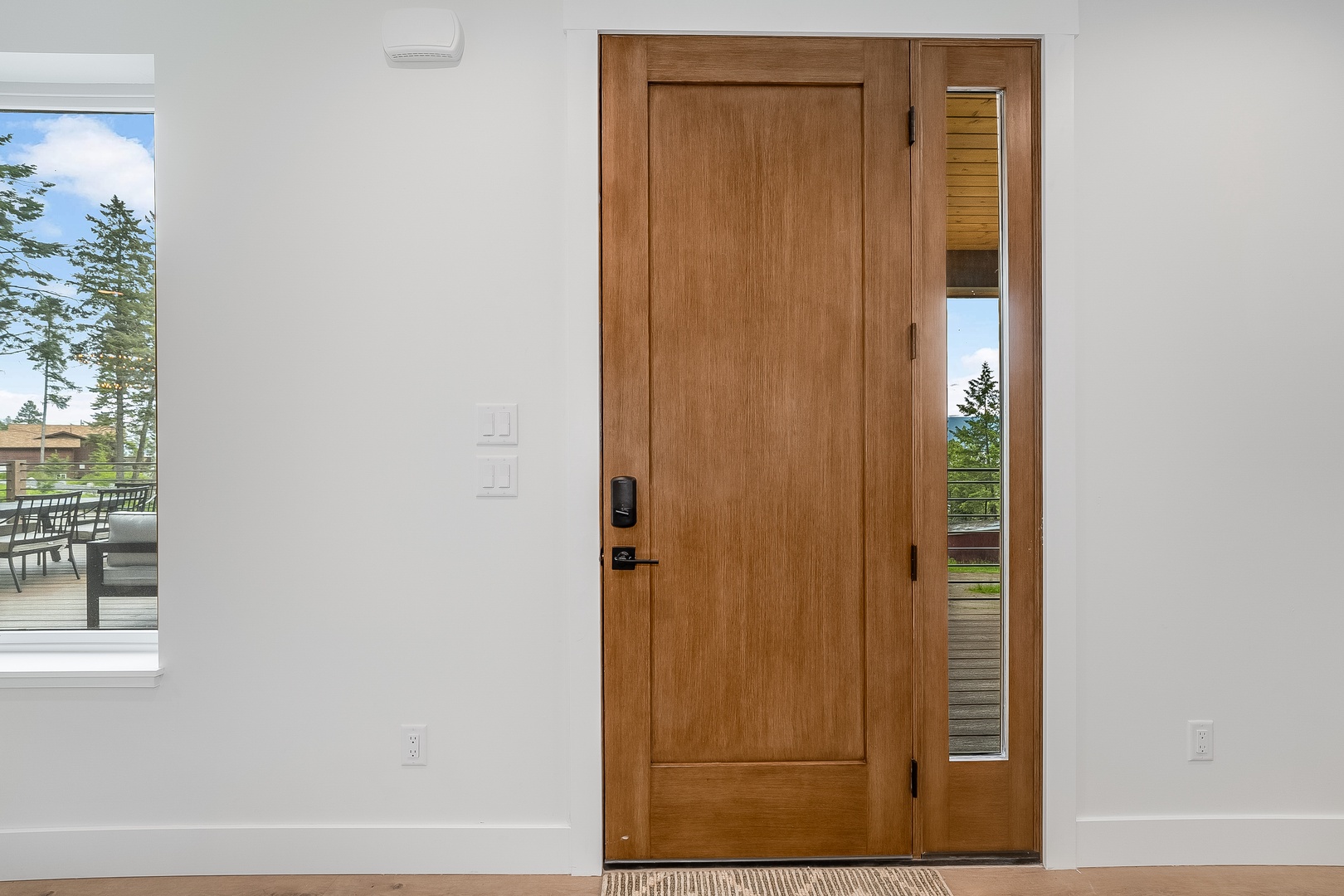 This modern entrance features a smart keyless lock for your easy, secure arrival. Bright windows frame scenic views and invite natural light into your welcoming space.