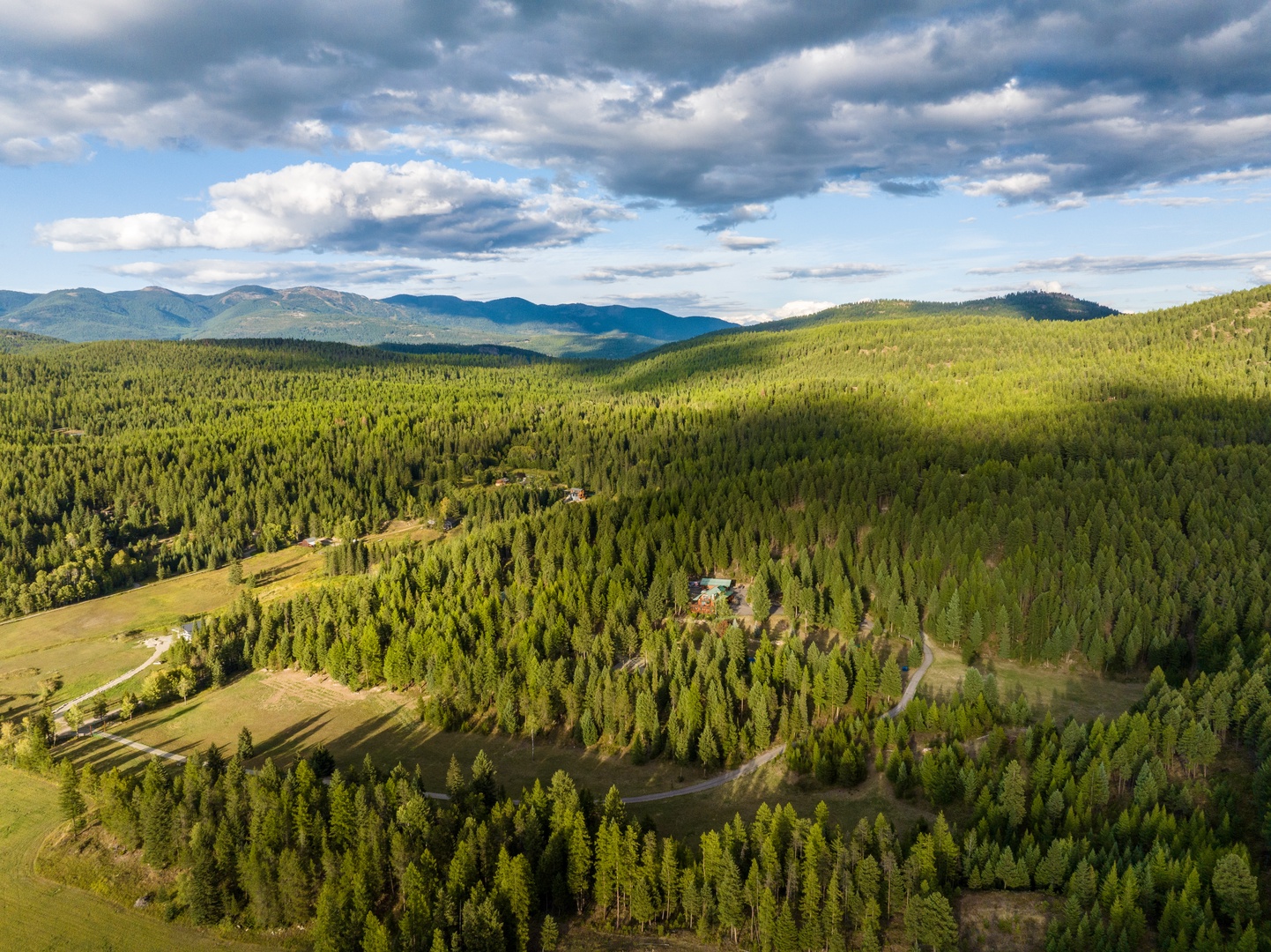 Aerial view of forested mountains and valleys showcasing the pristine natural landscape surrounding the property.