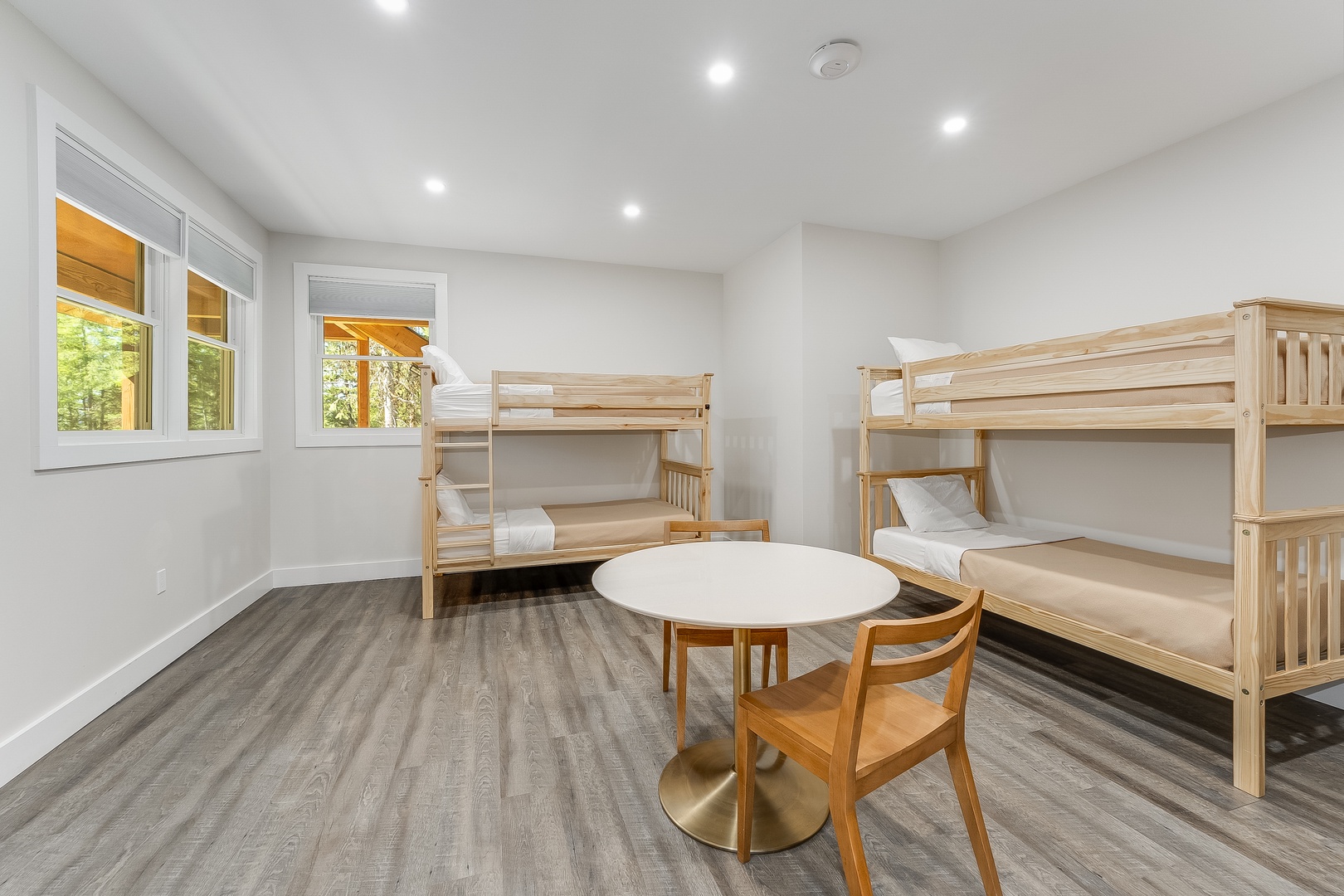 Your bright, spacious bunk room features sturdy wooden beds, a cozy play table, and views of greenery outside—perfect for kids to rest and create memories together.