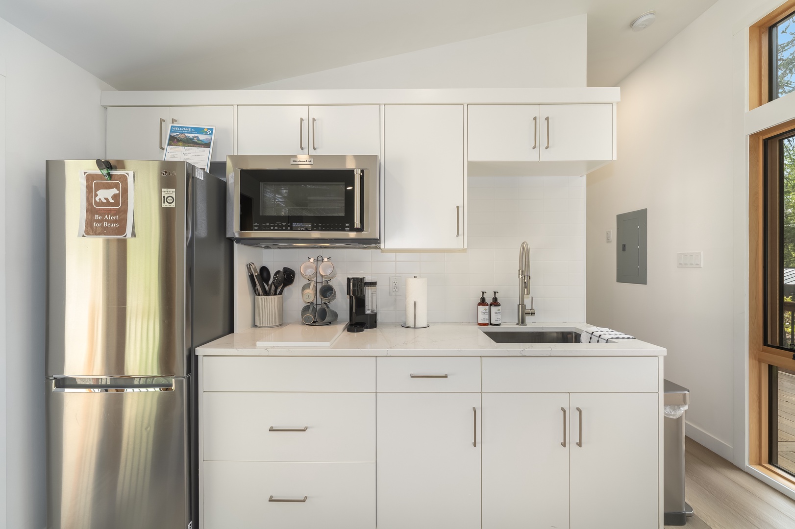 Your modern kitchenette features sleek white cabinetry, stainless steel appliances, and everything you need for easy meal prep. Brew coffee, chill snacks, and enjoy the bright, clean space.