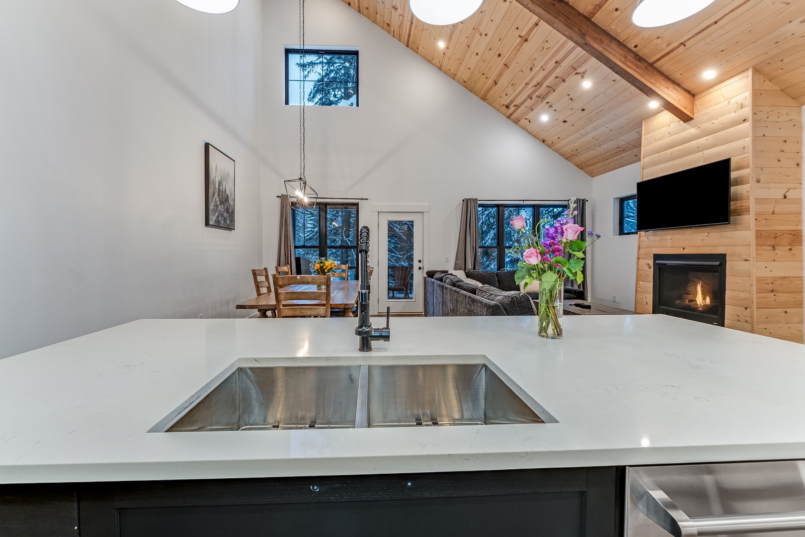Your kitchen island overlooks the open living space, where you'll gather around the fireplace after days exploring the forest.