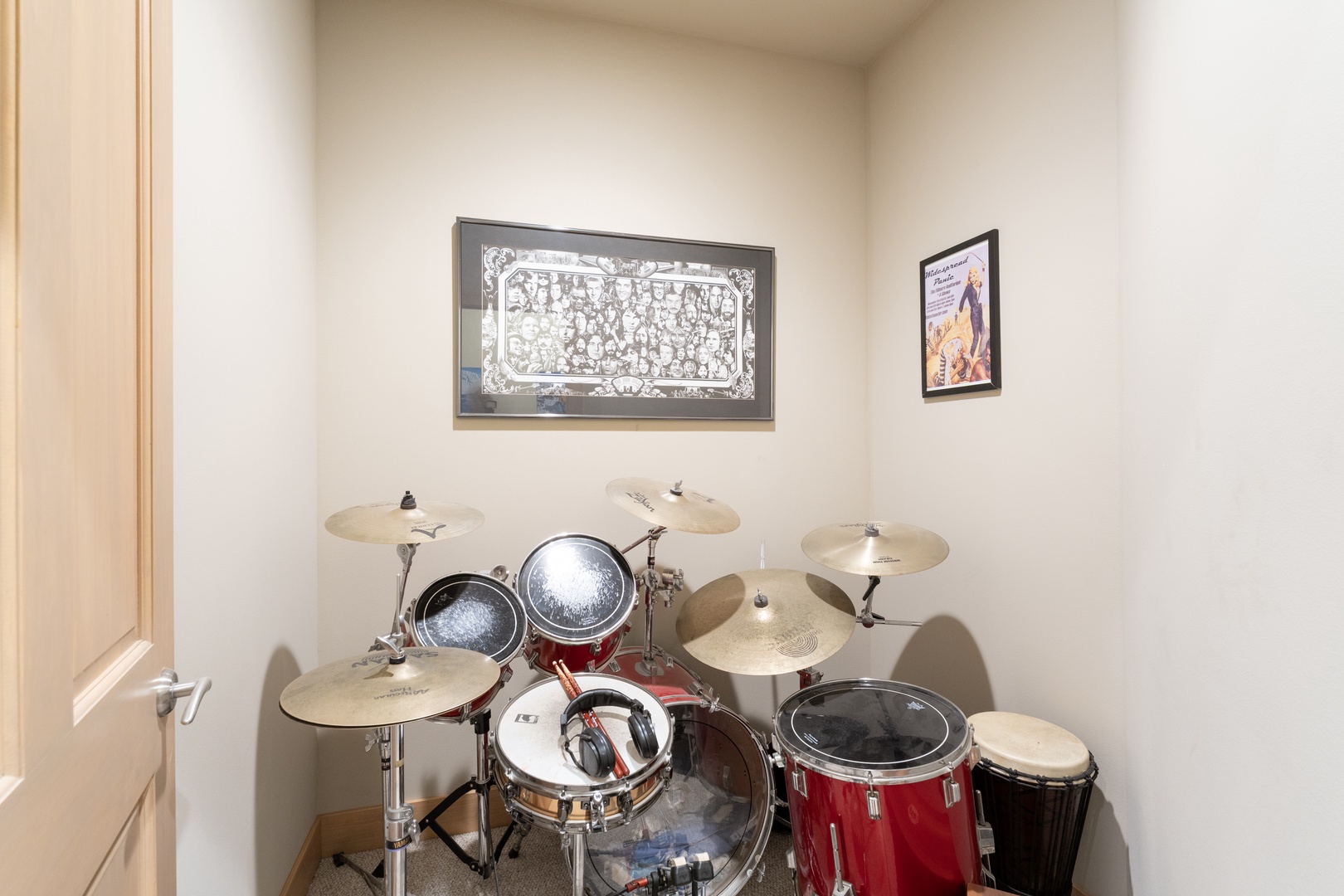 A dedicated music room awaits with a full drum set ready for your creative sessions, complete with wall art to inspire your rhythm.