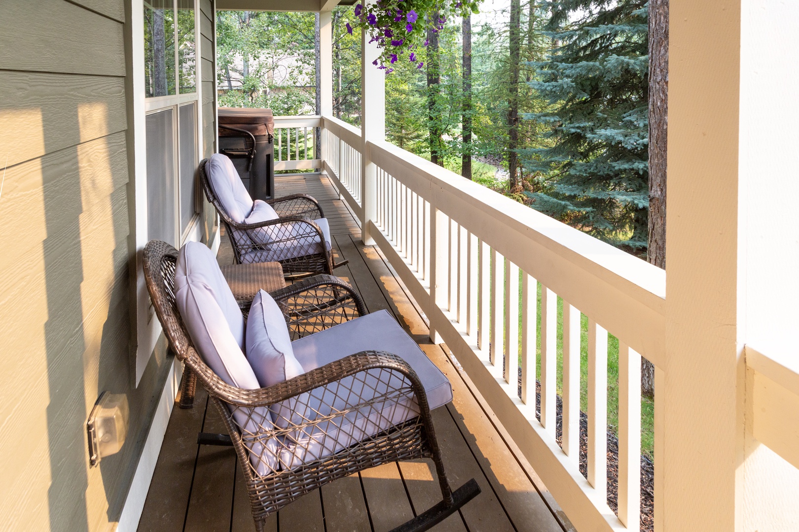 Relax in your private screened balcony with cozy wicker seating, surrounded by towering pines and fresh mountain air—your perfect retreat morning or evening.