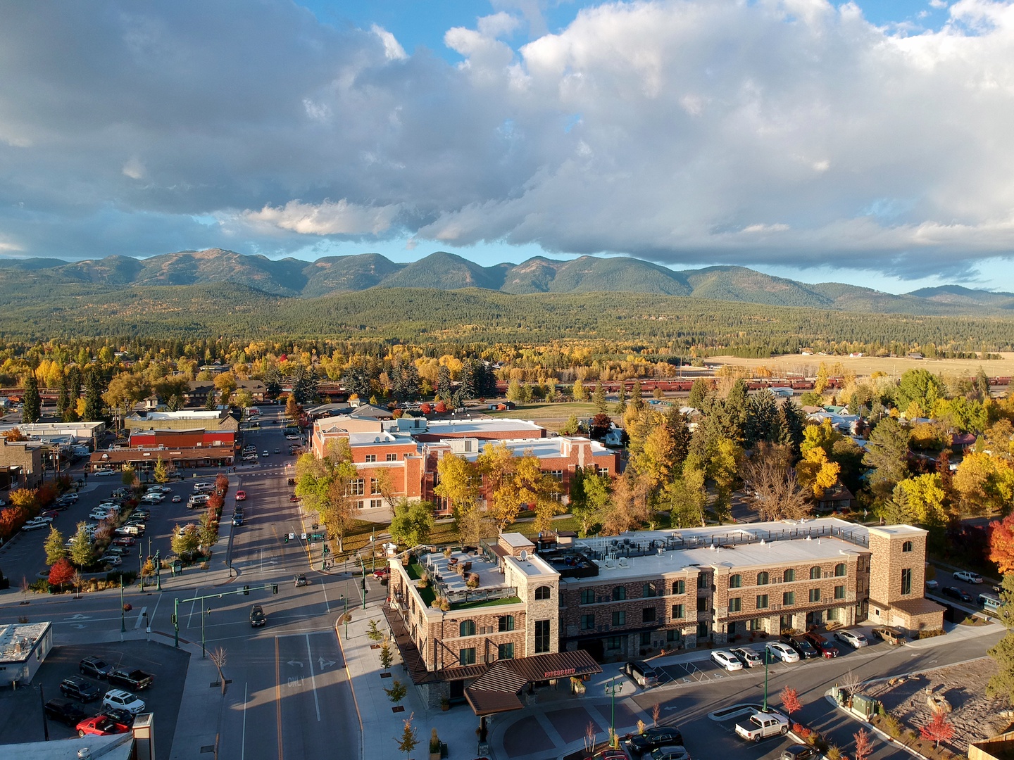 Aerial view of the charming downtown area surrounded by stunning mountain ranges and vibrant autumn foliage.