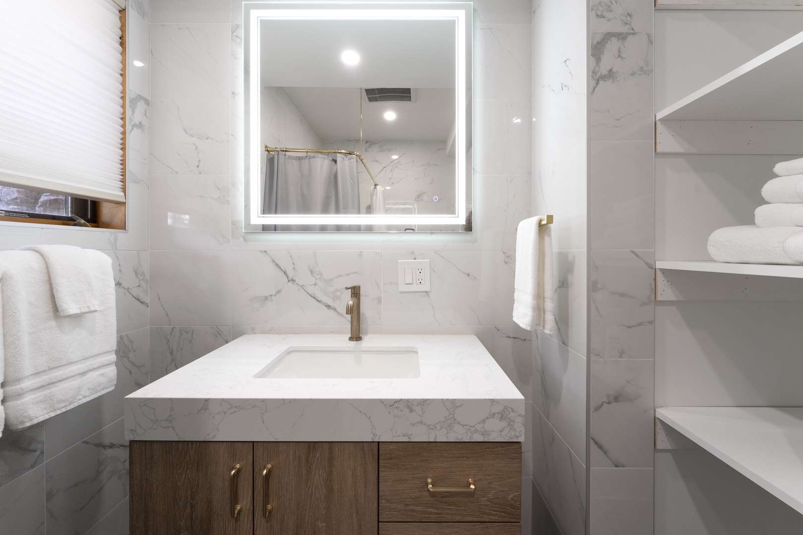 Step into your private spa-like bathroom, where marble-style tiles meet modern elegance. Fresh towels await, and an LED-lit mirror brings Hollywood glamour to your daily routine.