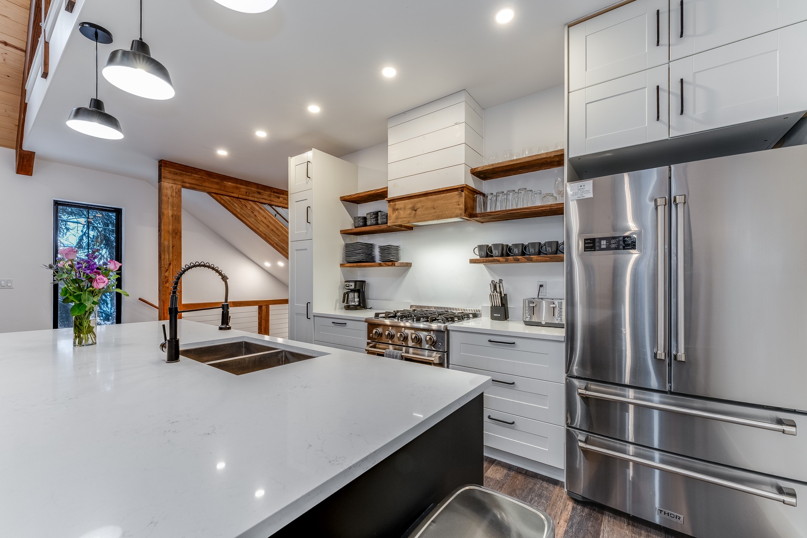 Cook memorable meals in this stunning modern kitchen with gleaming countertops, professional-grade appliances, and warm wood accents.