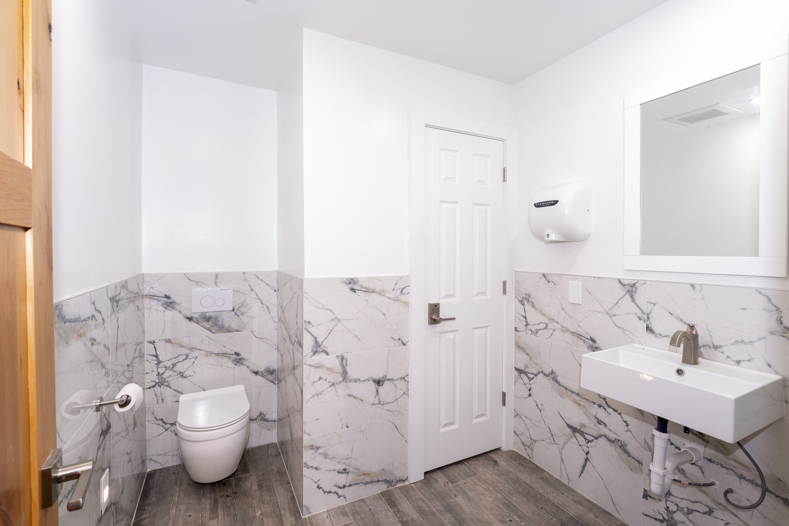 Bright, modern bathroom with elegant marble-look walls and a sleek vanity. You'll appreciate the contemporary fixtures and pristine cleanliness during your stay.