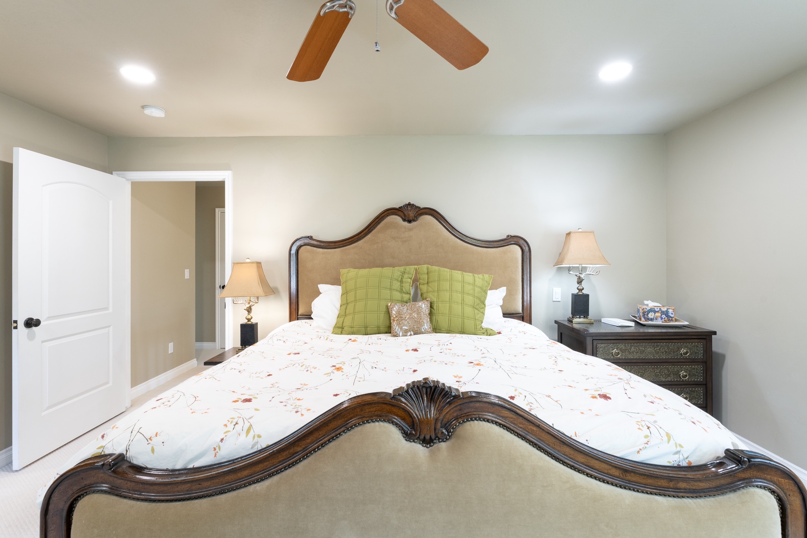 Sink into plush linens beneath the gentle breeze of your ceiling fan. This bedroom's elegant headboard and soft lighting create a peaceful haven for restful nights.