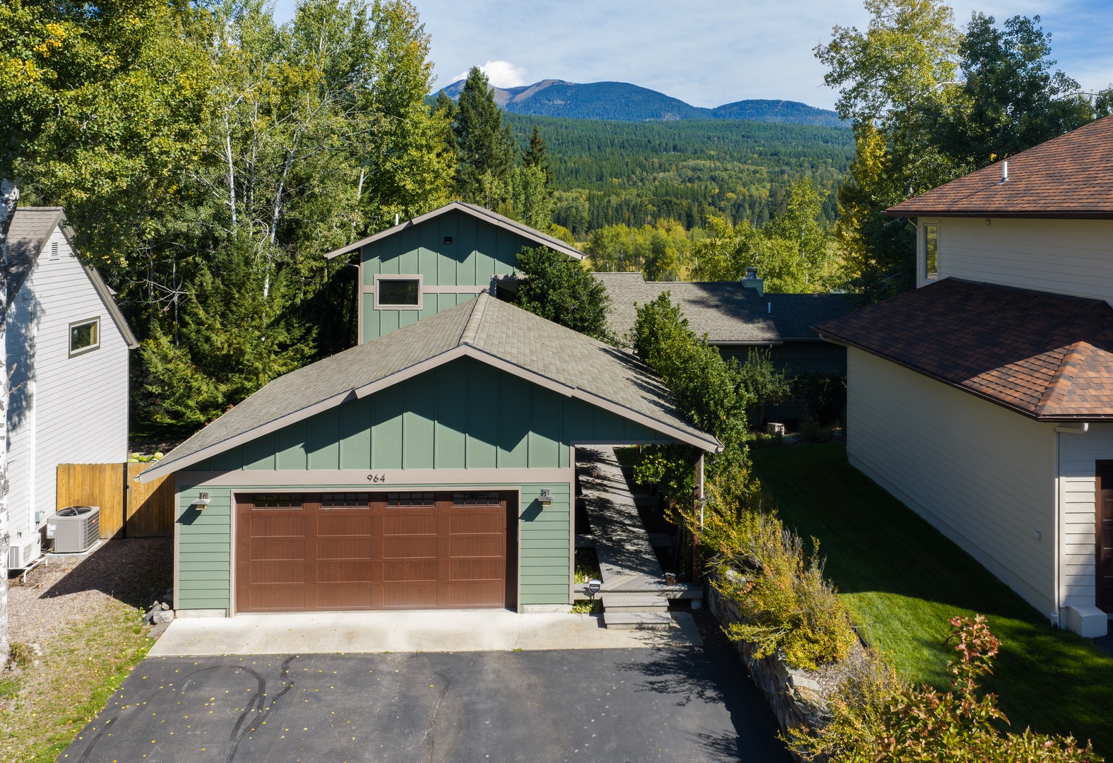 A charming rental in a peaceful neighborhood, framed by lush trees and majestic forested mountains—a perfect backdrop for a relaxing mountain getaway.