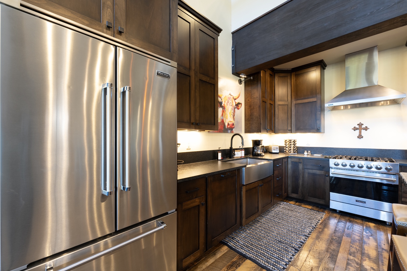 Your fully equipped kitchen features stainless steel appliances, rich wood cabinetry, and a farmhouse sink—perfect for preparing home-cooked meals while enjoying the warm, rustic charm.