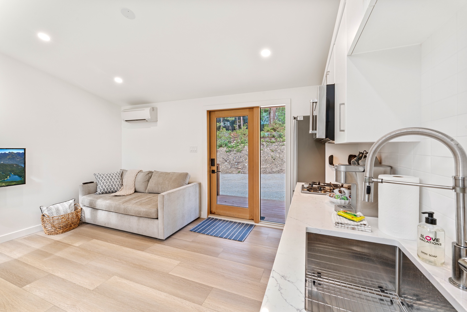 Your bright, modern living space flows seamlessly from kitchen to lounge, perfect for relaxing after exploring the area.