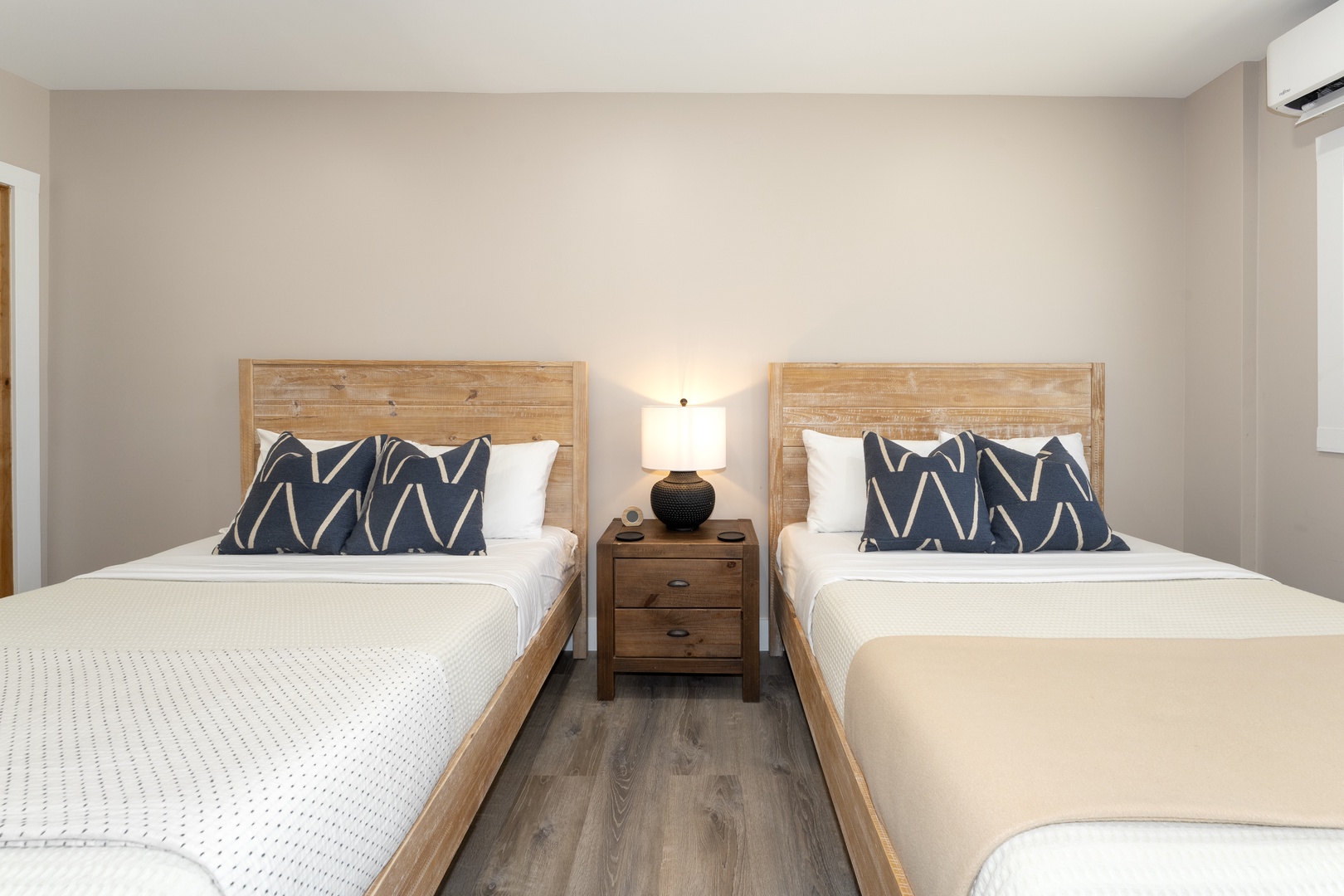 Unwind in your peaceful bedroom with two plush beds, crisp linens, and stylish accents. A warm bedside lamp and climate control ensure your ultimate comfort.