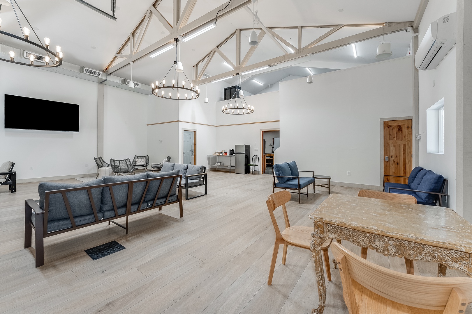 Unwind in this stunning open-concept living space, where soaring vaulted ceilings with exposed beams create an airy, inviting atmosphere for gathering and relaxing together.