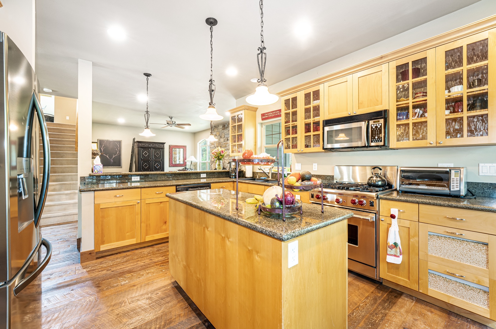 Your gourmet kitchen features warm wood cabinetry, granite counters, and stainless appliances—perfect for preparing memorable meals with plenty of counter space and natural light.