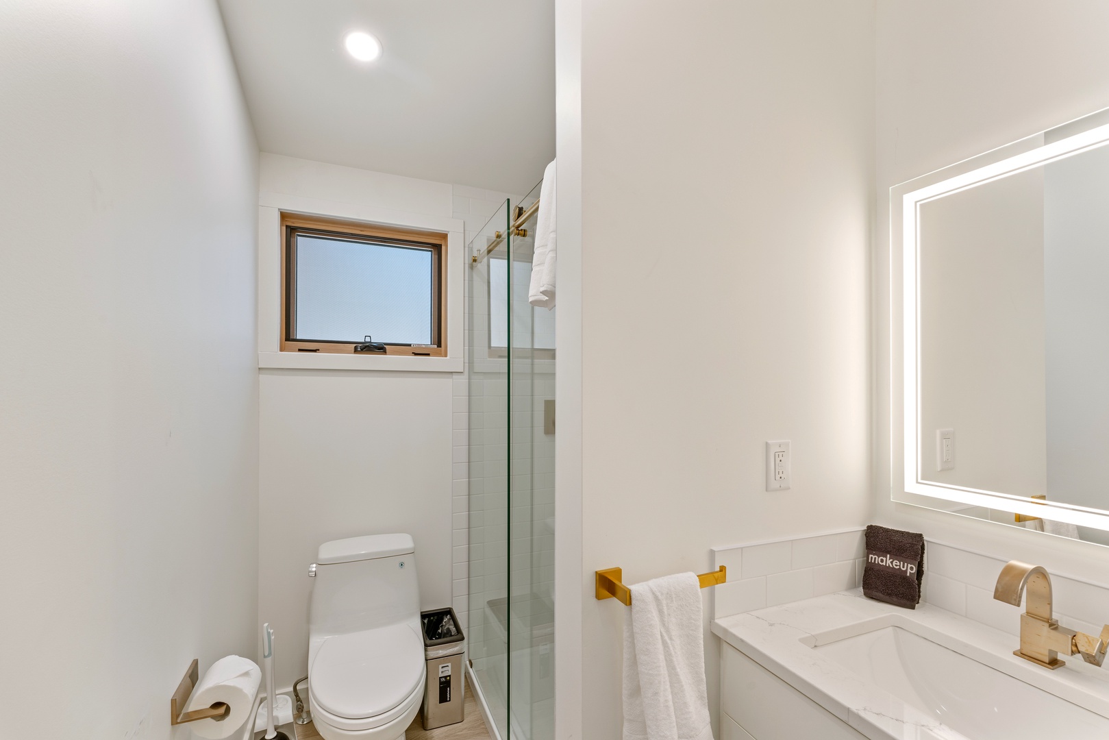 Step into your spa-like bathroom featuring a sleek glass shower, modern fixtures, and warm natural light from the window.