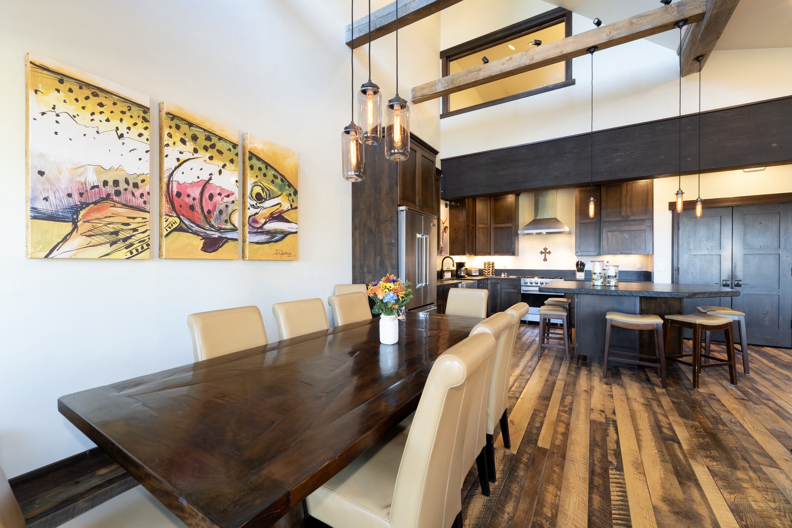 Gather around this stunning live-edge dining table beneath soaring ceilings and elegant pendant lights, with your fully-equipped gourmet kitchen just steps away.
