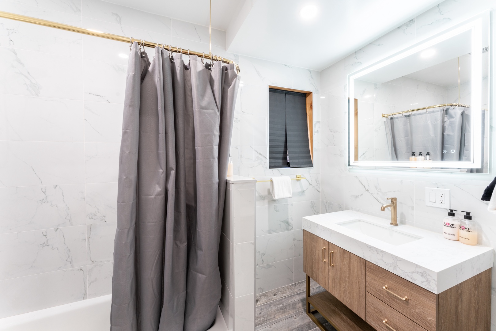 Step into your serene bathroom, where marble-inspired walls and warm wood tones create a spa-like retreat. Fresh towels and thoughtful amenities await your arrival.