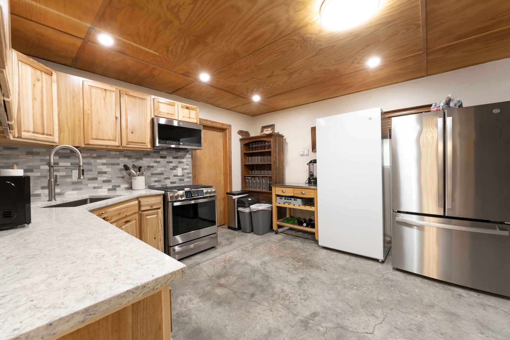 Step into your fully equipped kitchen with gorgeous wood-paneled ceilings, modern stainless appliances, and plenty of counter space for preparing meals during your stay.